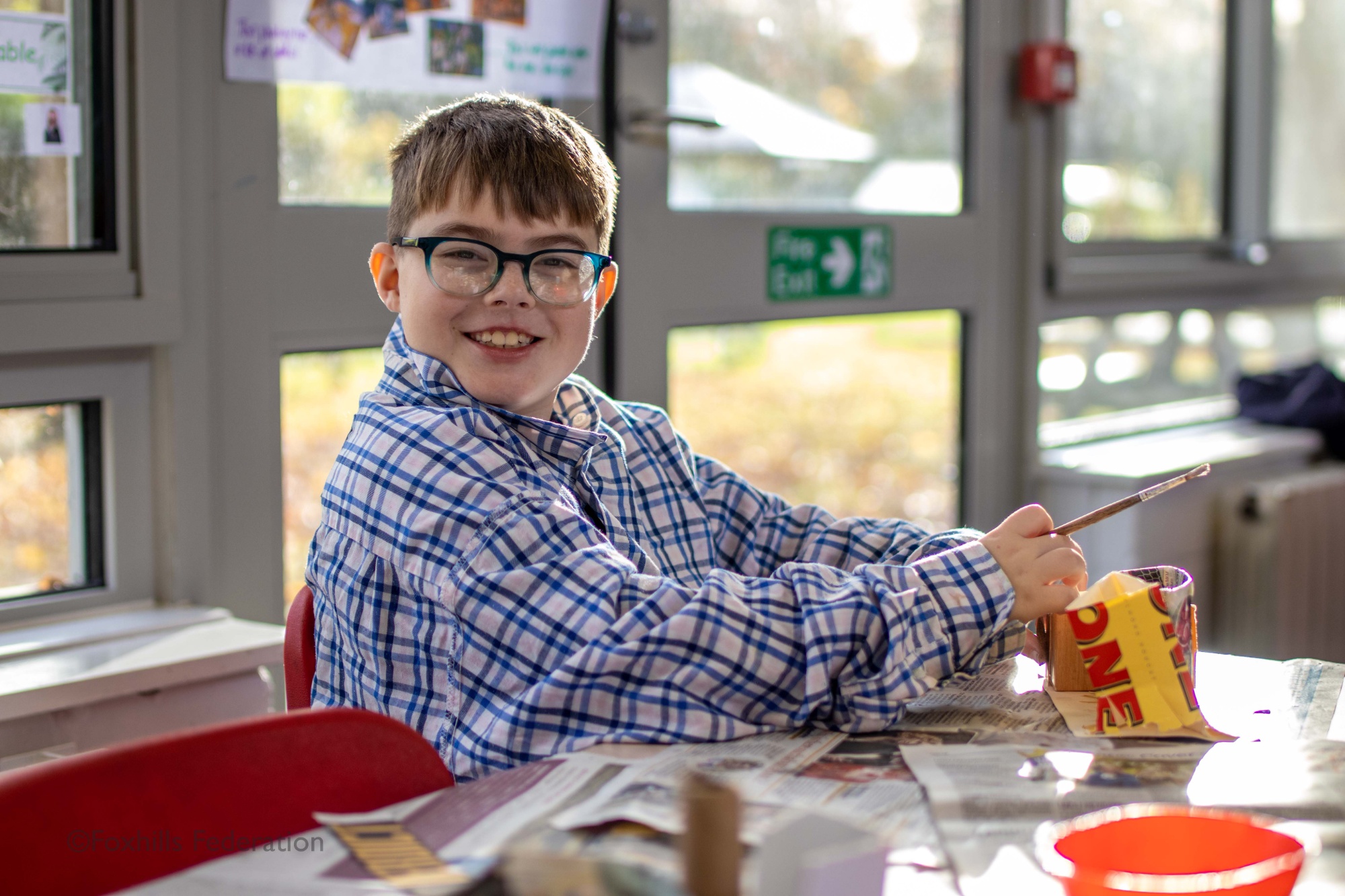 A boy makes a homemade desk tidy.