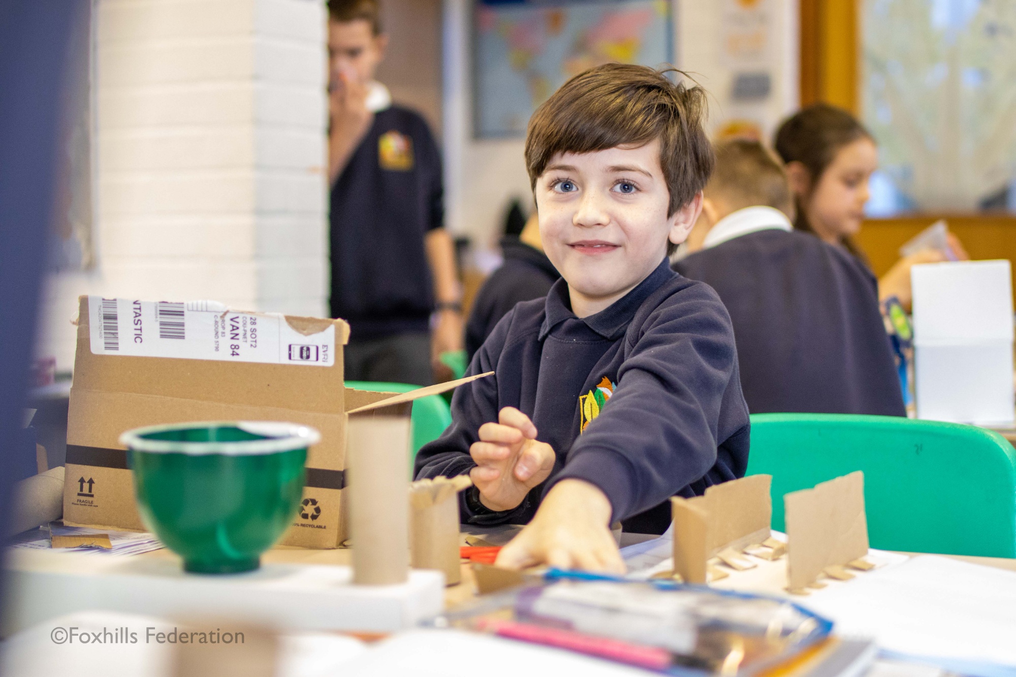 A boy makes a homemade desk tidy.