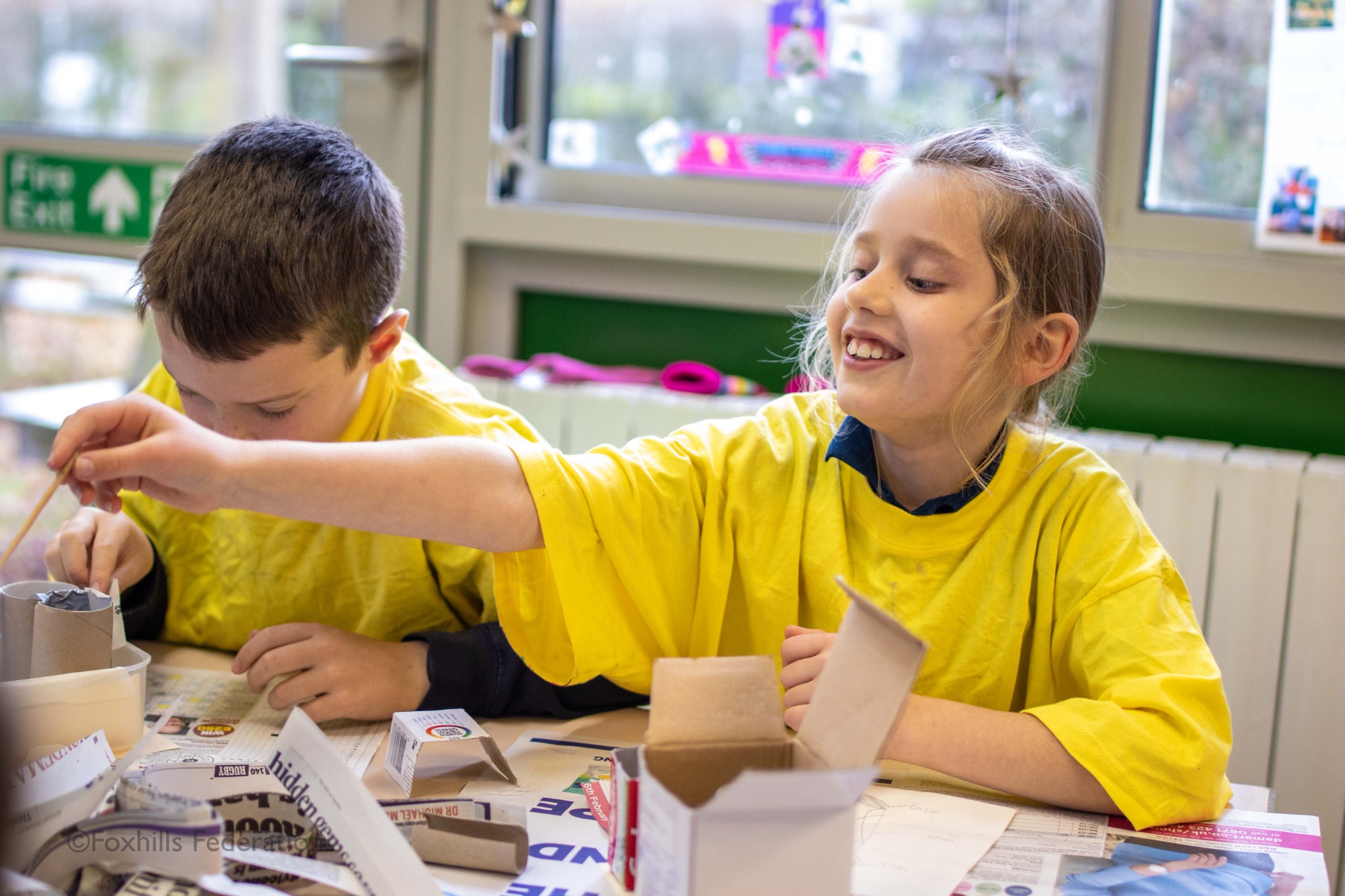 Children make homemade desk tidies.