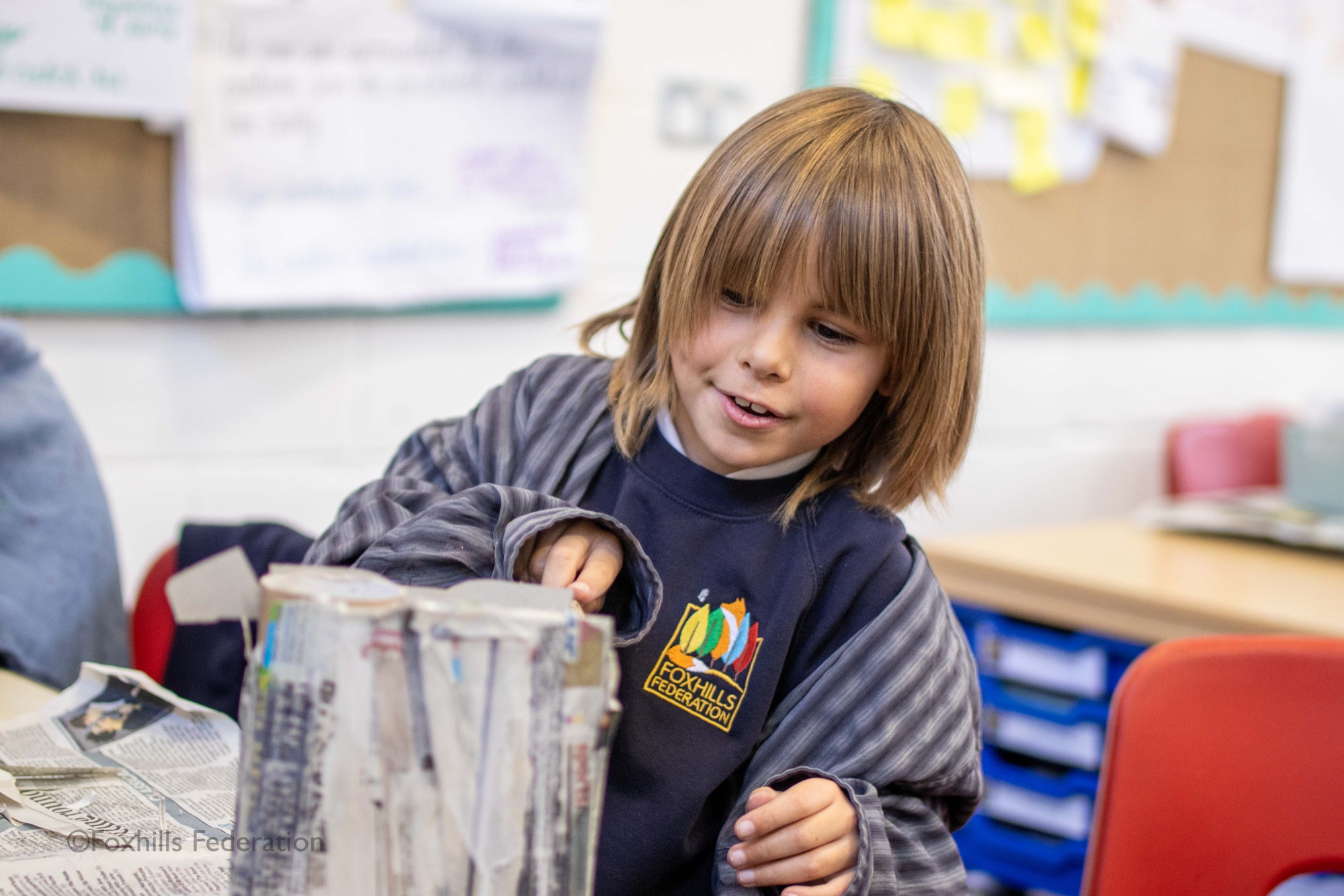 A boy makes a homemade desk tidy.