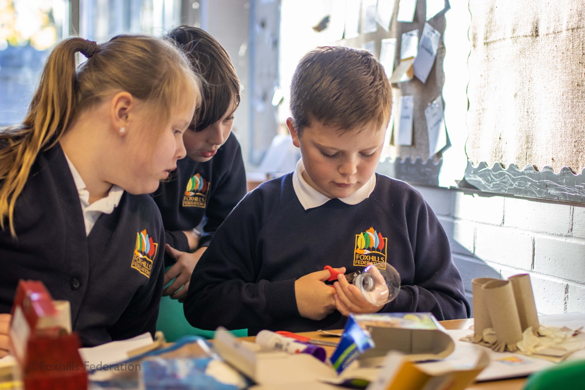 Children make homemade desk tidies.