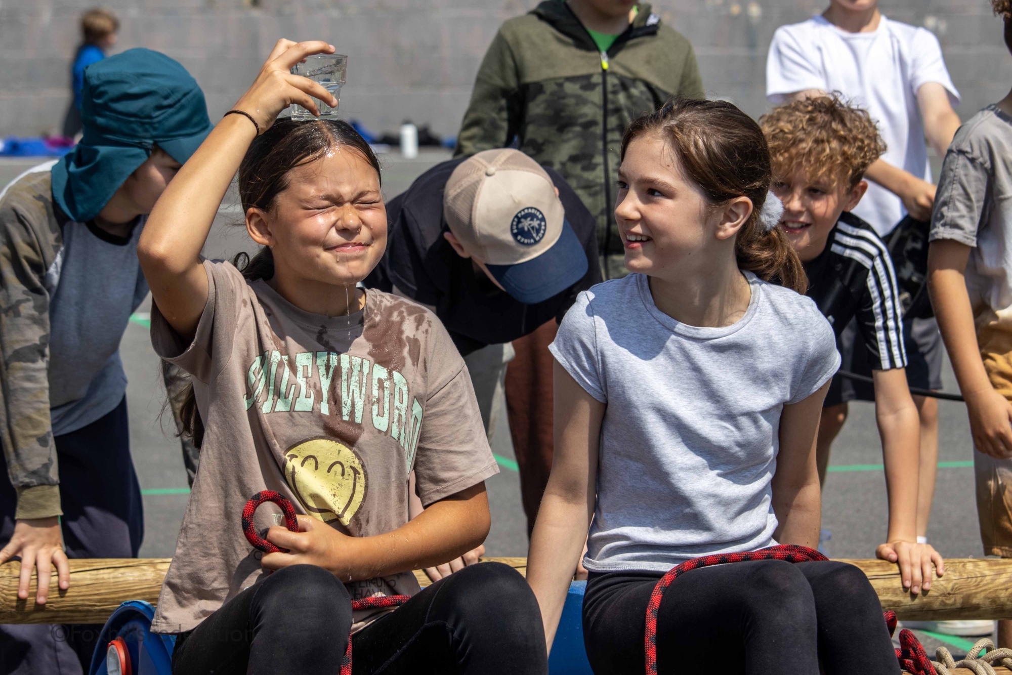A girl balances a glass of water on her head