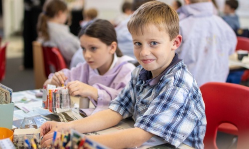 Children make homemade desk tidies.