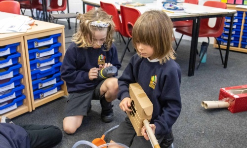 Children play homemade music instruments.