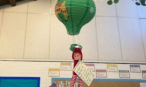 An elf holds onto a balloon.