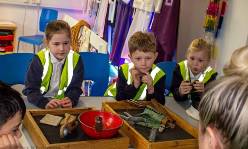 Children gather around objects from the SeaCity museum.